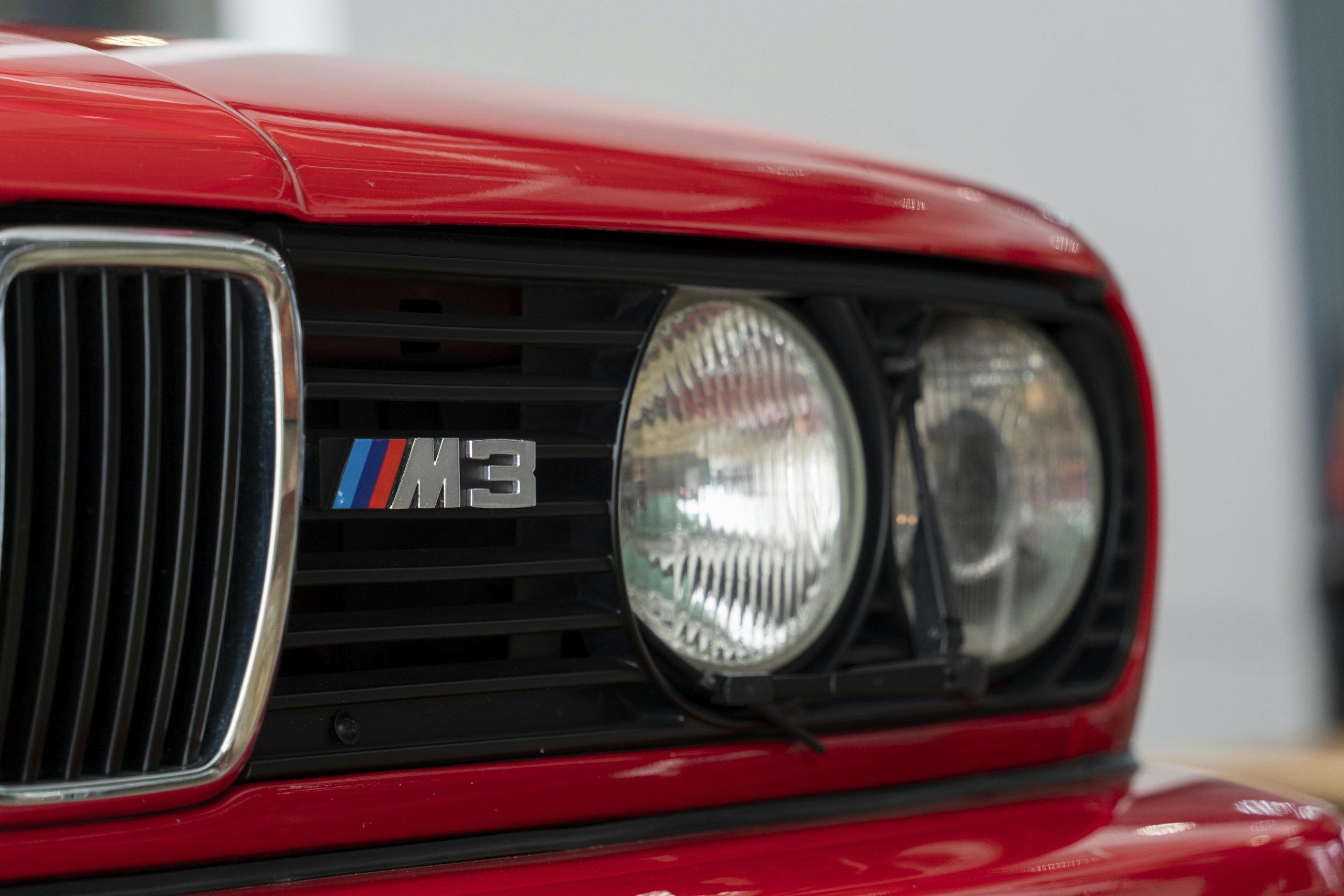 Крупний план червоного BMW M3 E30: капот, нирки решітки та круглі фари